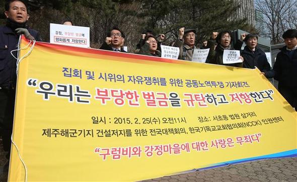 25일 오전 서울 서초구 서울중앙지법 앞에서 제주해군기지 건설저지를 위한 전국대책회의와 한국기독교교회협의회 인권센터가 연 기자회견에서 참가자들이 제주해군기지 건설 반대 집회 참가자들에게 부과된 벌금형에 항의하는 구호를 외치고 있다. 섬돌향린교회 임보라 목사, 이영욱씨 등은 벌금형이 기본권인 집회 결사의 자유를 부정한다며 이에 저항하기 위해 스스로 벌금이 아닌 노역을 택했다고 밝혔다. 제주해군기지 건설에 반대해온 강정마을 주민들과 활동가들에게 부과된 벌금 추산액은 4억원가량이다.  연합뉴스
