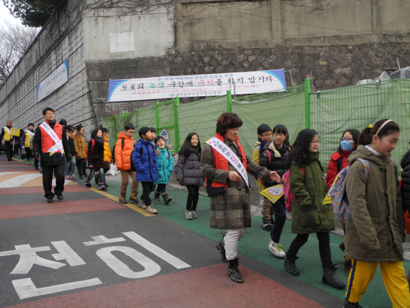 대구명덕초등학교의 등하굣길 프로그램 ‘워킹스쿨버스’에 참가한 학생들이 중구시니어클럽 봉사자들과 함께 학교로 향하고 있다. 　명덕초 제공