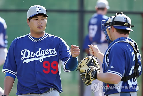 10일(한국시간) 미국 애리조나 글렌데일 캐멀 백 랜치 LA 다저스 훈련장에서 류현진이 릭 허니컷 투수코치 앞에서 불펜 투구를 마친 뒤 공을 받아 준 포수와 하이파이브를 하고 있다. 류현진은 실전처럼 공을 던지는 시뮬레이션 피칭 이틀만에 다시 불펜에 서 시범경기 출전 준비를 착착해 나가고 있다. (연합뉴스)