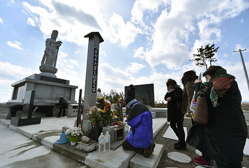 11일 미야기 센다이시 아라하마에서 시민들이 희생자를 추모하고 있다. 센다이/AFP 연합뉴스