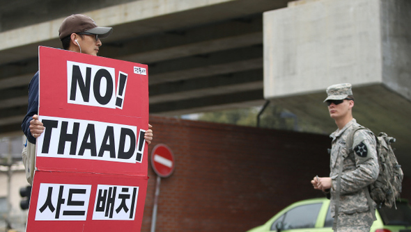 시민단체 평화와통일을여는사람들 회원이 18일 낮 서울 용산 주한미군기지 앞에서 미국의 고고도미사일방어체계인 사드(THAAD) 도입을 반대하는 1인 시위 하는 모습을 지나가던 미군이 바라보고 있다.  신소영 기자 viator@hani.co.kr