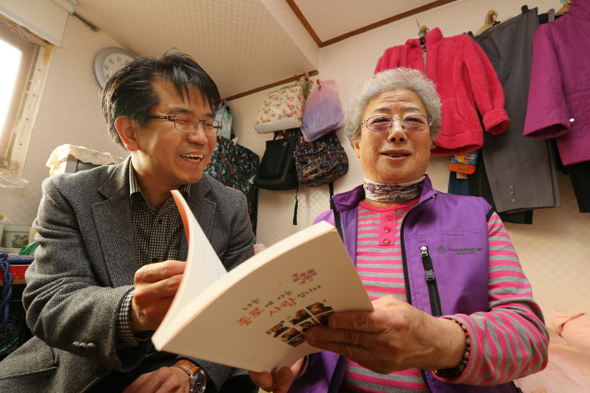 김옥순 할머니(오른쪽)가 20일 오후 서울 종로구 동숭동 집에서 박진옥 나눔과나눔 사무국장한테서 자신을 비롯한 독거노인들의 삶을 기록한 구술생애사 책 <나는 종로에 사는 사람입니다>를 받으며 환히 웃고 있다. 
 이정아 기자 leej@hani.co.kr