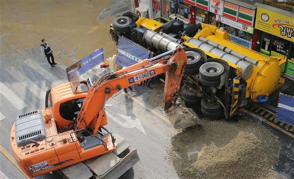 29일 오후 서울 서대문구 현대백화점 신촌점 앞 도로가 내려앉으면서 하수도 준설 차량이 인도 쪽으로 쓰러져 있다. 연합뉴스