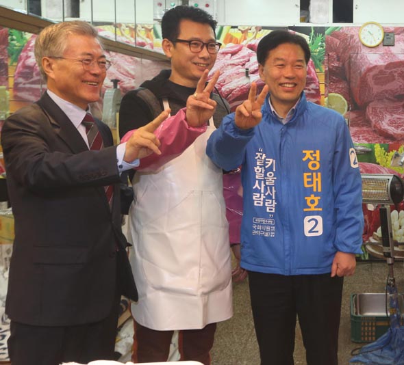 문재인 새정치민주연합 대표(왼쪽)가 30일 오전 재보궐선거를 앞둔 서울 관악을 선거구의 신원시장을 방문해 이 지역 정태호 후보(오른쪽)와 함께 상인들과 기념사진을 찍고 있다. 이정우 선임기자 woo@hani.co.kr