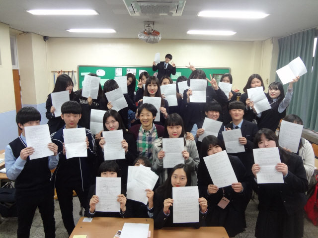 지난 3월31일 경기도 수원시 팔달구 삼일상업고등학교 1학년 6반 학생들과 담임 허진만 교사가 근로계약서를 작성해보는 수업을 마친 뒤 계약서를 들고서 웃고 있다.
