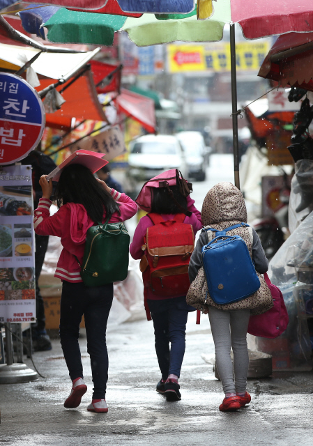 전국적인 봄비가 예고된 2일 오후 서울 관악구 조원동에서 수업을 마친 초등학생들이 책과 가방, 모자 등으로 소나기를 피한 채 귀가하고 있다. 기상청은 3일까지 서울·경기 남부와 강원 영서 남부, 충청 내륙과 전라도, 경상남도에는 10~40㎜, 강원도 영동과 경상북도에는 5~30㎜의 비가 내리겠다고 예보했다.  신소영 기자 viator@hani.co.kr