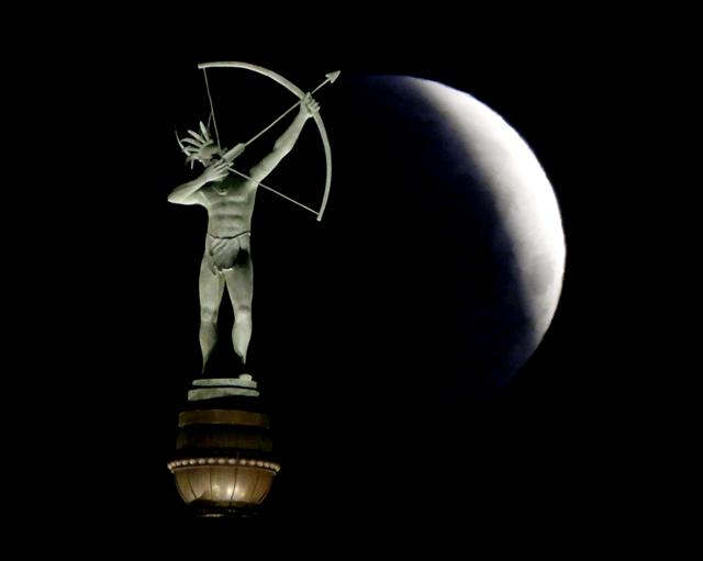 지난 4일(현지시각) 미국 캔자스주 의회의 캔사 인디언 동상 뒤로 보름달의 일부가 월식으로 가려지고 있다. 이번 월식은 21세기 월식 가운데 가장 짧은 것으로 기록됐다.   토페카/AP 연합뉴스  