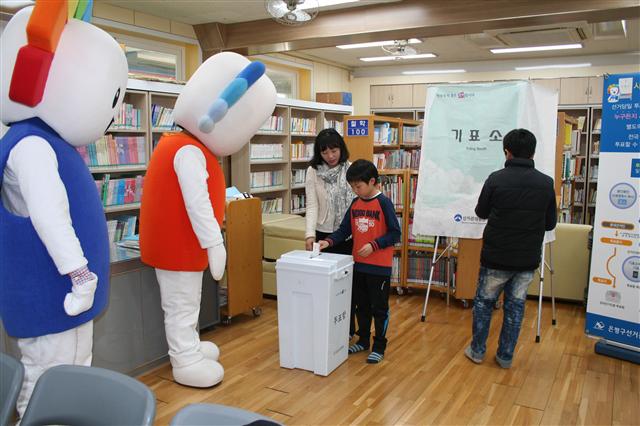 지난 2월25일 서울 은평구 연신초등학교 도서관에서 열린 ‘청소년 리더 연수 프로그램’에서 학생들이 사전투표 체험을 하고 있다.  최화진 기자
