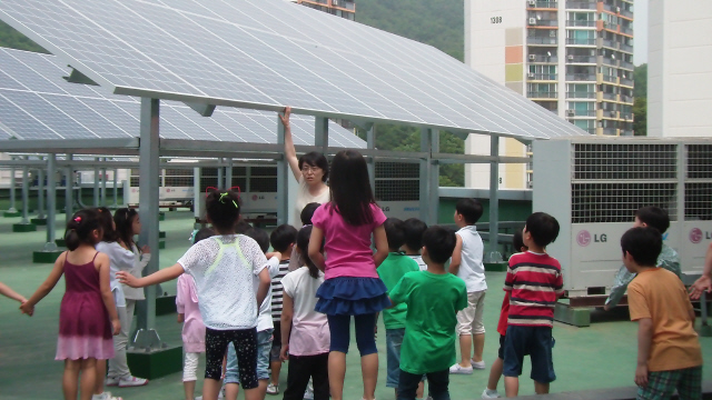 서울 노원구 상원초등학교 옥상에 지난해 4월 준공된 햇빛발전소의 태양광 설비. 이 학교 아이들이 담임 선생님과 함께 태양광 전지를 둘러보며 신재생에너지와 관련한 체험 수업을 하고 있다.   상원초등학교 제공