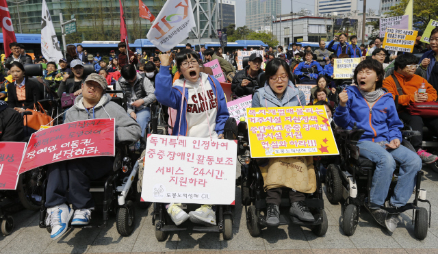 장애인의 날을 닷새 앞두고 ‘4·20장애인 권리찾기 대행진’ 참가자들이 15일 오후 서울 종로구 보신각 앞에서 주거·고용·이동 등 다양한 영역에서 장애인의 권리를 찾아 비장애인과 동등한 자립 생활을 보장받겠다며 집회를 열어 노래 <님을 위한 행진곡>을 부르고 있다. 이종근 기자 root2@hani.co.kr