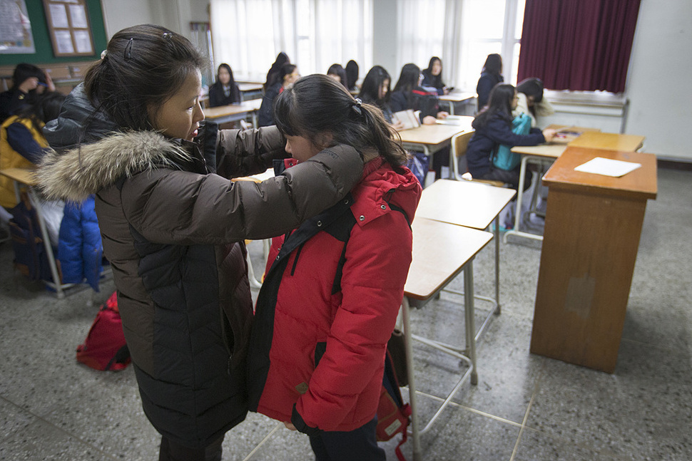 권남희 씨가 3월 2일 안산 단원구 원곡고등학교 1학년 교실에서 고등학교 입학식에 앞서 딸 박성혜 양의 옷 매무새를 고치고 있다. 안산/김성광 기자 flysg2@hani.co.kr