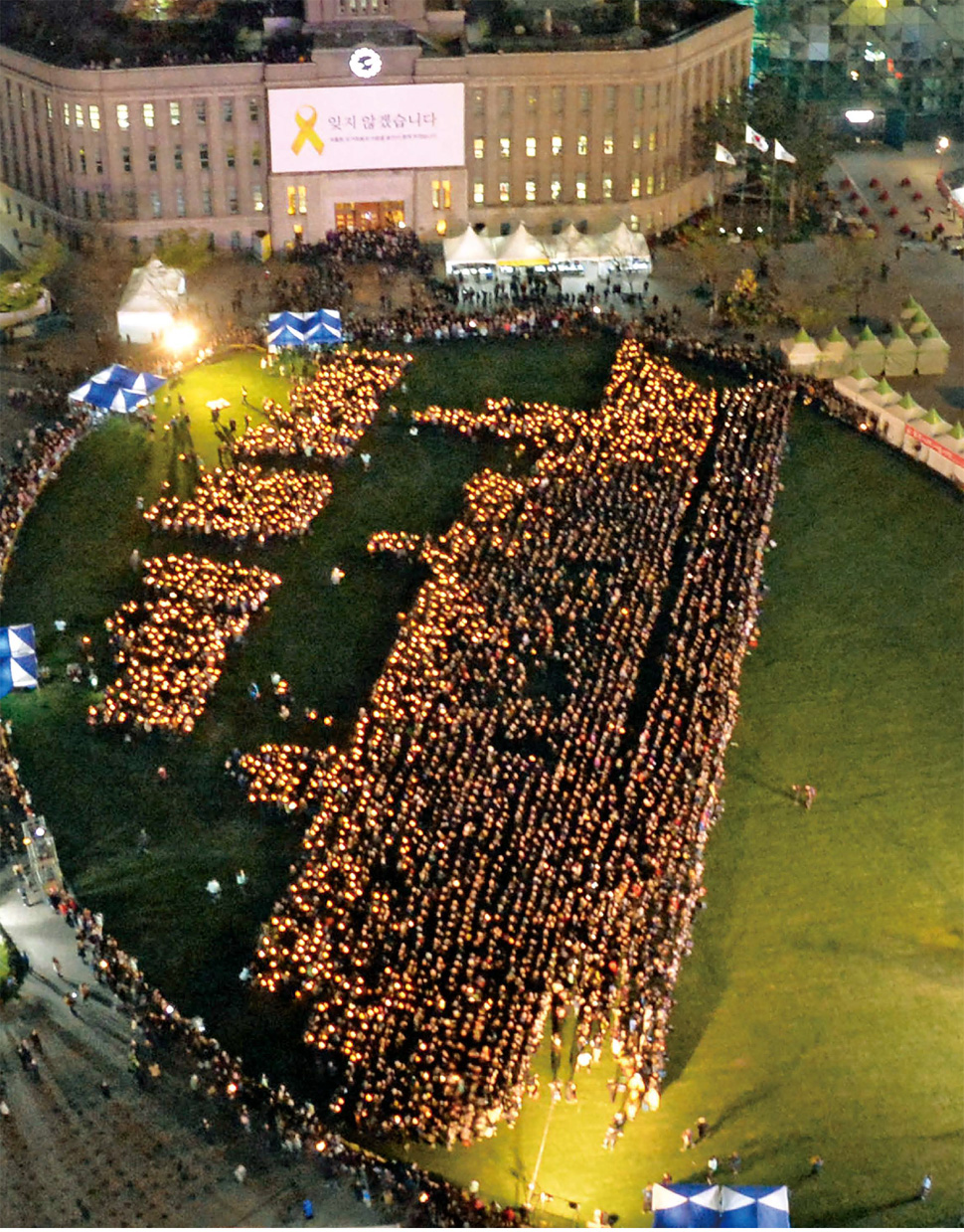  세월호 참사 1주기를 맞아 시민 4475명이 17일 밤, 서울시청 앞 서울광장에 모였다. 이들의 손에는 건전지로 작동하는 촛불 모양의 전구 하나씩이 들려 있었다. 이들은 세월호 참사를 추모하기 위해 진행된 ‘세상에서 가장 슬픈 도전’이란 이름의 행사에 참여하기 위해 모였다. 촛불을 든 사람들로 세월호 형상을 만드는 행사다. 행사를 주최한 민주주의국민행동과 세월호참사국민대책회의는 영국 세계기네스협회에 ‘사람이 만든 가장 큰 촛불 이미지’에 도전하기 위해 시민 4160명을 모으려 했지만, 시민들은 꼬리를 물며 행사장에 입장해 목표보다 300명 이상 늘어났다. 행사장에 입장하지 못한 500여명은 서울광장 바깥에서 지켜볼 수밖에 없었다. 이 슬픈 도전은 이날 밤 9시6분 기네스북 등재에 성공했다. 
김미향 기자 <A href="mailto:aroma@hani.co.kr">aroma@hani.co.kr</A>, 사진 공동취재사진 