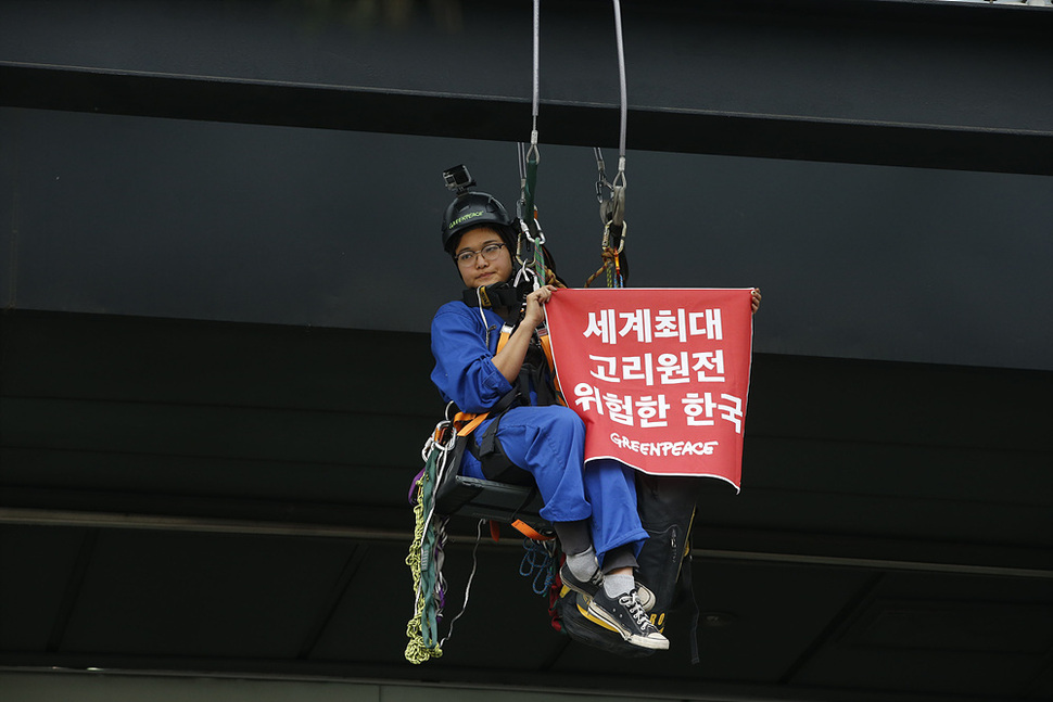 그린피스 활동가가 23일 오전 서울 세종로 원자력안전위원회 건물에 줄을 묶고 공중에 매달려, 신고리 3호기 가동을 반대하는 시위를 벌이고 있다. 이정아 기자 leej@hani.co.kr