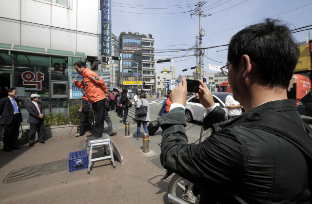 선거 감시는 선거관리위원회만 할 수 있는 일이 아니다. 선관위는 시민들의 자발적인 선거 감시를 독려하고 있다. 전국공무원노동조합이 선거감시단을 꾸려 활동에 나섰다. 국회의원 재보궐선거가 치러질 예정인 서울 관악을 지역구의 한 시장에서 23일 오후 권종만 공무원노조 서울지역본부 부정부패추방위원장이 유세 현장을 휴대전화 카메라에 담고 있다. 강재훈 선임기자 khan@hani.co.kr