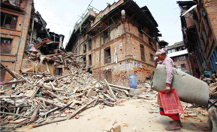  26일 네팔 수도 카트만두에서 북동쪽에 있는 박타푸르의 한 여성이 지진으로 무너진 집 앞에서 망연자실한 모습으로 서 있다. 박타푸르/UPI 연합뉴스
