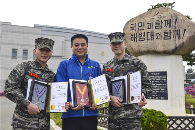  해병대 예비역인 유승국(46·가운데)씨가 해병대 1사단 21대대 본부중대에서 근무하는 아들 유재상(22·왼쪽) 상병·유준상(20·오른쪽) 일병과 함께 적십자 헌혈유공장 금장과 은장을 들고 기념촬영을 했다. 모두 115회 헌혈을 기록중인 3부자는 지난해 백혈병 환자를 위해 헌혈증 100장을 기증했다.  
연합뉴스