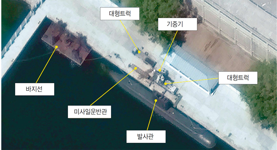 북한이 잠수함 탄도탄 수중발사에 성공했다고 발표한 직후인 지난 10일 미국 민간위성사진 업체인 ‘디지털 글로브’가 북한 신포 조선소 전경을 촬영한 위성사진. 미국의 위성사진 분석업체 ‘올소스 어낼리시스’는 사진 왼쪽편에 보이는 바지선이 이번에 잠수함 탄도탄을 발사하는 데 쓰인 것으로 보인다고 주장했다. 잠수함이 정박해 있는 부두에는 대형트럭 2대와 기중기 1대, 발사관, 미사일 운반관 등이 관찰되고 있다. 연합뉴스