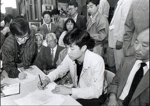 1991년 ‘유서 대필’ 누명을 쓴 강기훈이 명동성당에서 기자회견을 하면서 유서의 필적과 자신의 글씨체가 다르다는 걸 증명하기 위해 똑같은 내용을 써 보이고 있다. 그 왼편은 취재를 하고 있는 필자다.