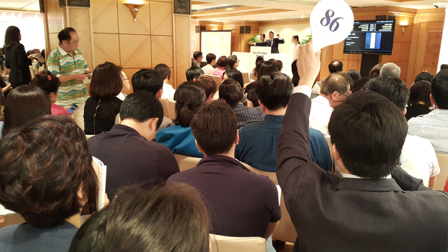  30일 저녁 홍콩 그랜드하얏트 호텔에서 열린 서울옥션의 경매 현장. 연단 중앙의 중국인 경매사가 모인 고객들 앞에서 단색조 그림의 주문을 권하자 한 고객이 손팻말을 들어올리며 응찰가격을 부르는 모습이다.