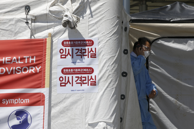 방역복과 마스크를 착용한 한 의사가 3일 오전 서울 종로구 연건동 서울대병원 안에 설치된 메르스 의심 환자 임시 격리실에서 진료를 마친 뒤 나오고 있다.  이정아 기자 leej@hani.co.kr