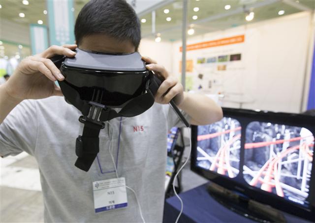 ‘2015년 스마트테크쇼’가 9일 서울 강남구 코엑스에서 열려 한 관람객이 가상현실(VR) 기기를 사용해 보고 있다. 아이티 기술의 현주소와 미래를 볼 수 있는 이 행사는 11일까지 열린다.  연합뉴스