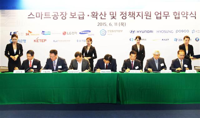 산업통상자원부와 중소기업청이 11일 서울 중구 대한상공회의소 중회의실에서 열린 ‘스마트공장 보급확산을 위한 업무협약식’에서 9개 업종별 대표기업 등과 업무협약 서류에 서명을 하고 있다. 이관섭 산업통상자원부 1차관은 협약식에서 저성장과 엔저 등으로 경제여건이 어려운 상황이지만 국내 산업에 스마트공장 도입으로 제조업 전반의 생산방식에 효율을 더해 경쟁력을 회복할 수 있다고 말했다.  산업통상자원부 제공 