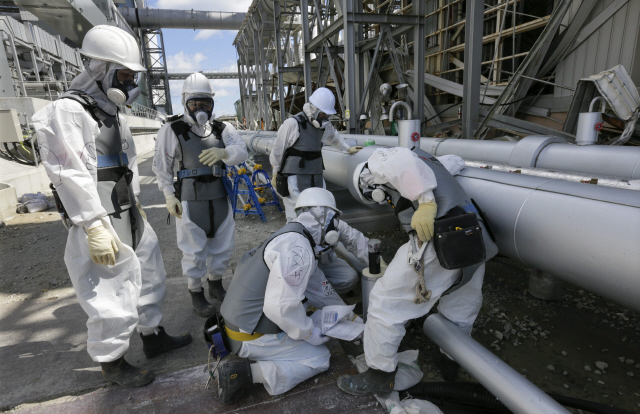 <b>후쿠시마 여전히 ‘위험지대’</b> 지난해 5월 일본 도쿄전력 직원과 방사능 전문가들이 후쿠시마 제1원자력발전소 원자로 4호기 옆에서 방사능에 오염된 침출수가 바다로 흘러나가지 못하도록 냉각 동결시키는 작업을 하고 있다. 2011년 3월 최악의 원전사고를 빚은 이곳의 원자로들은 현재 폐쇄 작업이 진행중이다. EPA/연합뉴스