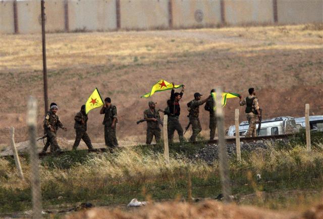 시리아의 쿠르드족 민병대인 ‘인민수비대’(YPG) 대원들이 15일 시리아와의 국경지대에 위치한 터키의 샨르우르파 주의 악차칼레 인근에서 인민수비대 깃발을 들고 이슬람국가(IS)로부터 주요 요충지인 탈 아브야드를 탈환한 것을 기뻐하고 있다.  악차칼레/AFP 연합뉴스