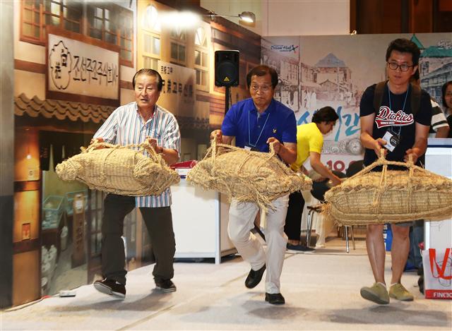 2일 오전 서울 강남구 삼성동 코엑스에서 열리고 있는 ‘2015 한국축제박람회’에서 관람객들이 군산 시간여행 축제 쌀가마 나르기 게임을 하고 있다. 연합뉴스