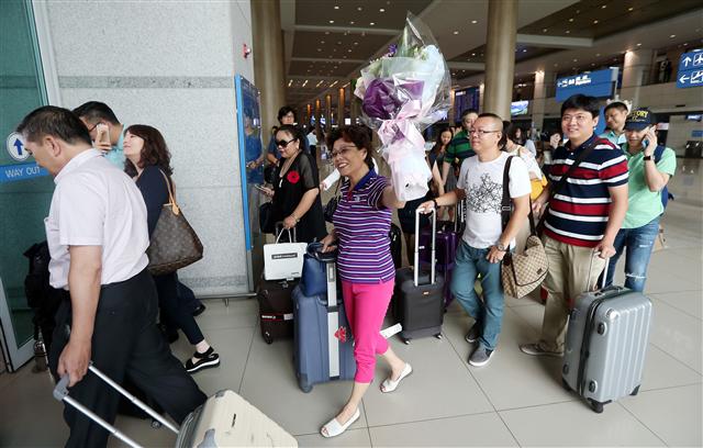 한국을 찾은 중국인 관광객들이 13일 오후 인천국제공항 입국장에서 환영식을 마친 뒤 본격적인 한국 관광을 위해 나서고 있다. 대한항공은 중동호흡기증후군(메르스) 사태로 타격을 입은 중국발 항공 수요의 회복을 돕고자 이날 중국 단체 여행객 환영행사를 마련했다고 밝혔다.  인천공항/연합뉴스