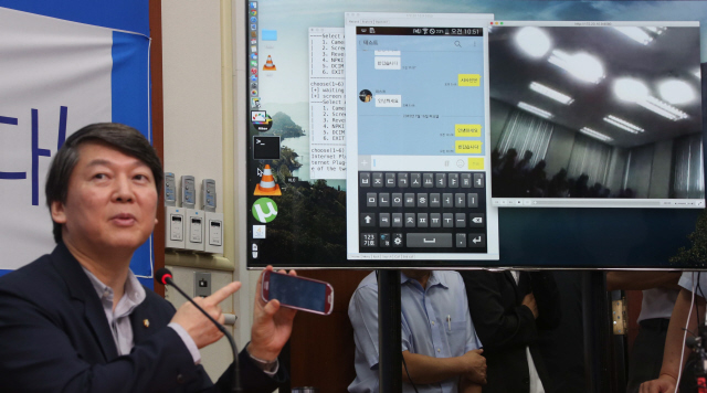 안철수 새정치민주연합 국정원불법사찰의혹진상규명위원장이 16일 오전 국회에서 ‘국정원 불법 해킹프로그램 및 악성코드 감염검사’를 시연하는 자리에서 자신의 스마트폰을 외부 컴퓨터에서 해킹해 카톡 대화를 감청하는 상황을 대형 화면으로 보여주고 있다.  이정우 선임기자 woo@hani.co.kr