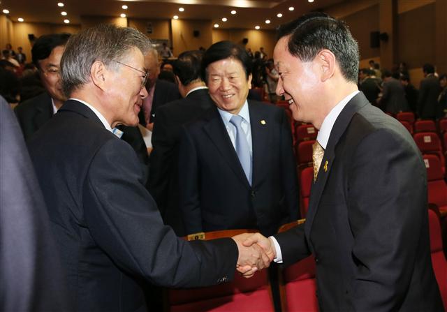 문재인 새정치민주연합 대표(왼쪽)와 김상곤 혁신위원장이 20일 오후 국회 의원회관에서 열린 중앙위원회에서 사무총장직 폐지를 뼈대로 한 혁신안이 통과된 뒤 환하게 웃으며 악수하고 있다.  연합뉴스