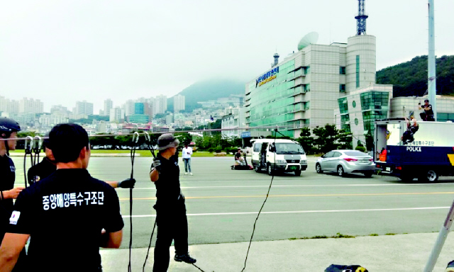 중앙해양특수구조단이 21일 훈련시설이 없는 탓에 부산해양경비안전서 조명탑에 밧줄을 매달아 부상자를 들것으로 이송하는 훈련을 하고 있다.