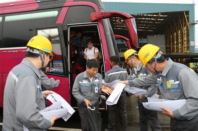 대우조선해양의 팀장 이상 임원들이 22일 오전 경남 거제 옥포조선소에서 출근하는 직원들에게 ‘위기 극복을 위한 임원 결의문’을 나눠주고 있다.  대우조선해양 제공