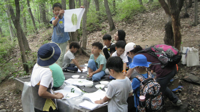 21일 오후 경기 군포시 산본동 수리산산림욕장에서 열린 ‘군포 대야미 오만가지 즐거운 꿈의 학교’ 생태교실 수업에서 초등학생들이 손수건에 나뭇잎 물들이기 수업을 하고 있다.