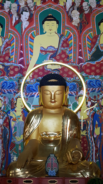 빛나는 광배를 형상화한 김기라 작가의 동그란 엘이디 조명조각. 백련사 대웅보전 본존불 뒤에 설치돼 실제 빛을 내뿜고 있다. 사진 노형석 기자
