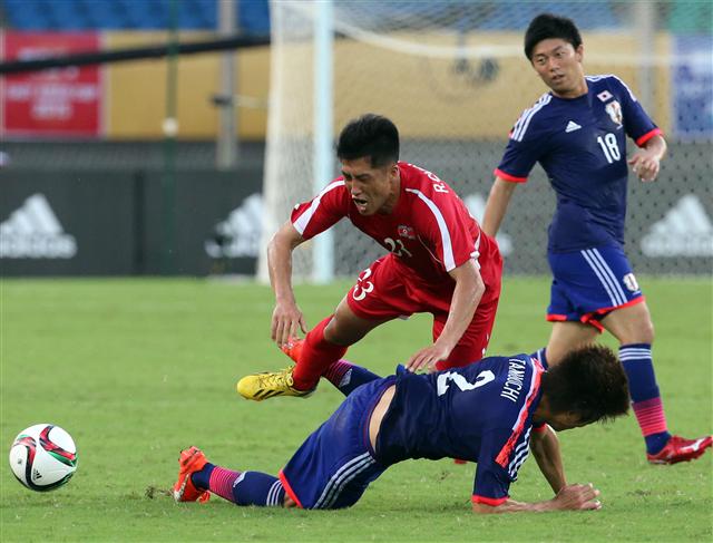 동아시안컵 축구대회 북한과 일본의 경기가 열린 2일 중국 후베이성 우한스포츠센터에서 북한 리철명(뒷줄 왼쪽)이 일본 쇼고와 볼을 다투다 엉켜 넘어지고 있다. 이날 북한은 후반 43분 장신 공격수 박현일의 역전 헤딩골로 일본에 2-1로 역전승했다. 우한/연합뉴스