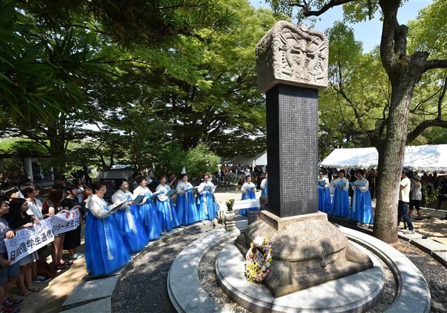 일본 히로시마 원자폭탄 투하 70주기를 하루 앞둔 5일 히로시마 평화공원에 있는 ‘한국인 원폭 희생자 위령비’ 앞에서 한국 여성들이 추모곡을 부르고 있다. 1945년 8월6일 미군은 히로시마에 원자폭탄을 떨어뜨렸고 20만명이 희생됐는데, 조선인도 2만명가량 희생된 것으로 추정된다. 히로시마에는 군수공장이 여럿 있었고, 강제징용된 많은 조선인들이 공장에서 일했다. 히로시마/AFP 연합뉴스