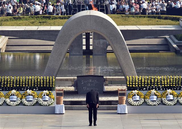 아베 신조 일본 총리가 히로시마 원자폭탄 투하 70주기인 6일 히로시마 평화기념공원에 있는 원폭 희생자 위령비 앞에서 참배를 하고 있다. 히로시마/AFP 연합뉴스