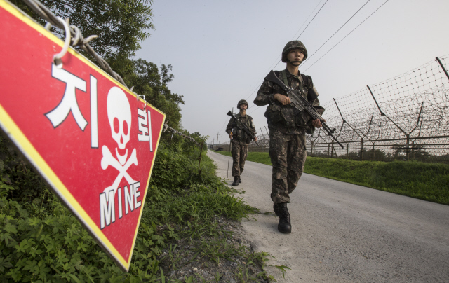 비무장지대(DMZ) 지뢰폭발 사고로 남북관계에 군사적 긴장이 고조된 가운데 11일 오후 장병들이 서부전선 철책 부근에서 경계활동을 하고 있다. 길가에 지뢰 매설을 알리는 안내판이 붙어 있다.  김성광 기자 flysg2@hani.co.kr