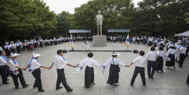 광복 70돌을 기념해 독립유공자와 1945년에 태어난 ‘해방둥이’들이 14일 오전 서울 강남구 도산공원에서 ‘아리랑’을 부르며 도산 안창호 동상 주변을 돌고 있다.  김성광 기자 flysg2@hani.co.kr