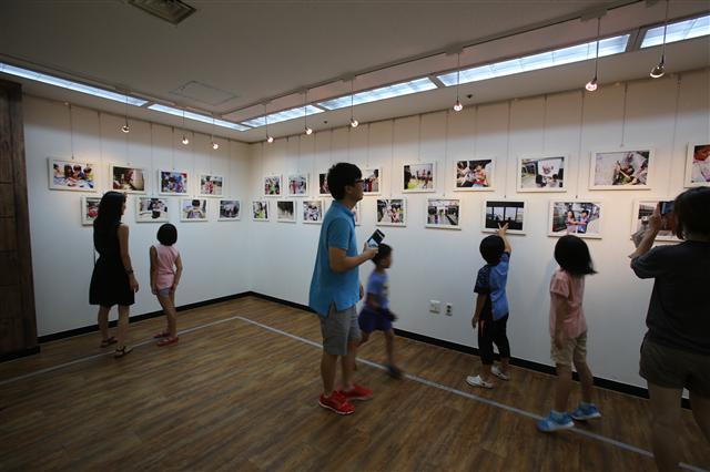 2. 지난 8일 서울 은평구 은평문화예술회관에서 열린 ‘꾸마사진전’에서 작가로 참여한 아이들이 서로의 사진을 보고 있다.  프로젝트룩 제공 