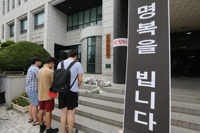 18일 오후 부산 금정구 장전동 부산대 본관 건물 앞에서 이 학교 학생들이 전날 이 건물에서 뛰어내려 숨진 국문과 고현철 교수의 명복을 빌고 있다.   부산/김봉규 기자 bong9@hani.co.kr