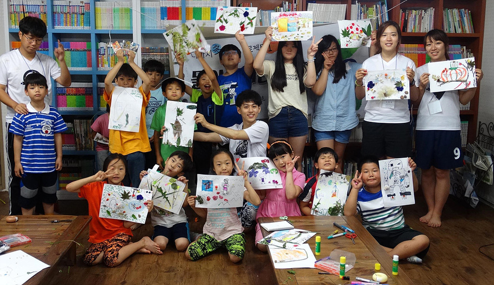 충남 청양공부방에서 대원들이 아이들과 함께 그림을 그린 뒤 그림을 들어보이고 있다.
