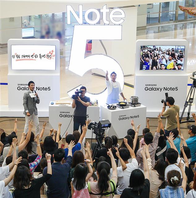 삼성전자가 오는 30일까지 서울 강남구 삼성동 코엑스몰에서 갤럭시노트5 체험 행사 ‘노트5 로드’를 연다고 24일 밝혔다. 삼성전자는 디자인, 그립감, S펜, 무선충전, 삼성페이 등 5개 주제로 전시를 마련했다. 모든 부스를 방문해 일정 과제를 수행한 소비자들에게는 매일 선착순에 따라 에버랜드 티켓을 준다.  삼성전자 제공 