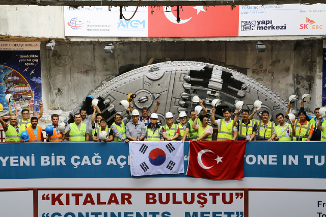 터키 정부와 에스케이(SK)건설 현장 임직원들이 22일(현지시각) ‘유라시아 해저터널’의 바다 밑 구간을 관통한 뒤 터널굴착장비(TBM) 앞에서 기념촬영을 하고 있다.  에스케이건설 제공