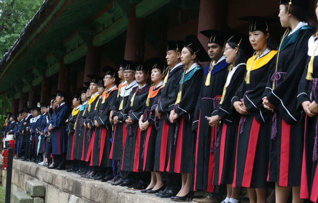 25일 오전 서울 종로구 성균관대학교 대성전에서 2326명의 졸업을 알리는 고유례(조선시대 성균관 유생들의 졸업식) 중 비가 내리자 참석한 졸업생들이 처마 밑에서 비를 긋고 있다.    김경호 선임기자 jijae@hani.co.kr