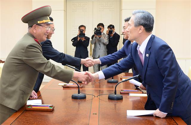 김관진 청와대 국가안보실장(앞줄 오른쪽)과 황병서 인민군 총정치국장(앞줄 왼쪽)이 지난 8월 25일 새벽 판문점 평화의집에서 남북 고위급 접촉을 마친 뒤 악수하고 있다. 뒷줄 오른쪽은 홍용표 통일부 장관, 왼쪽은 김양건 노동당 대남담당 비서. 통일부 제공