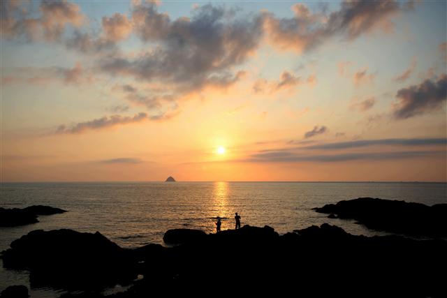 충남 보령 삽시도의 진너머해변 옆 바위자락에서 바라본 해넘이. 앞 섬이 멍데기다. 사진 이병학 선임기자
