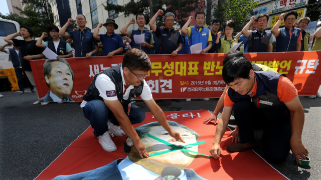 <b>노동계 “새누리당 막말 멈춰라”</b> 민주노총 조합원들이 3일 오후 서울 여의도 새누리당사 앞에서 ‘김무성 대표 반노동 막장발언 규탄 긴급기자회견’을 열어, 포스터에 그려진 김 대표 얼굴의 입 부위에 ‘×자’ 모양으로 테이프를 붙이고 있다. 김경호 선임기자 jijae@hani.co.kr